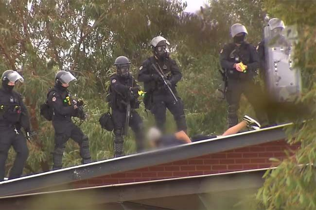 A child prisoner is detained by police during a recent rooftop riot at Banksia Hill (Screenshot via YouTube)