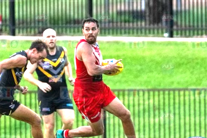 Jeremiah Rivers (in red uniform) playing football in the Northern Territory. (AFLNT)